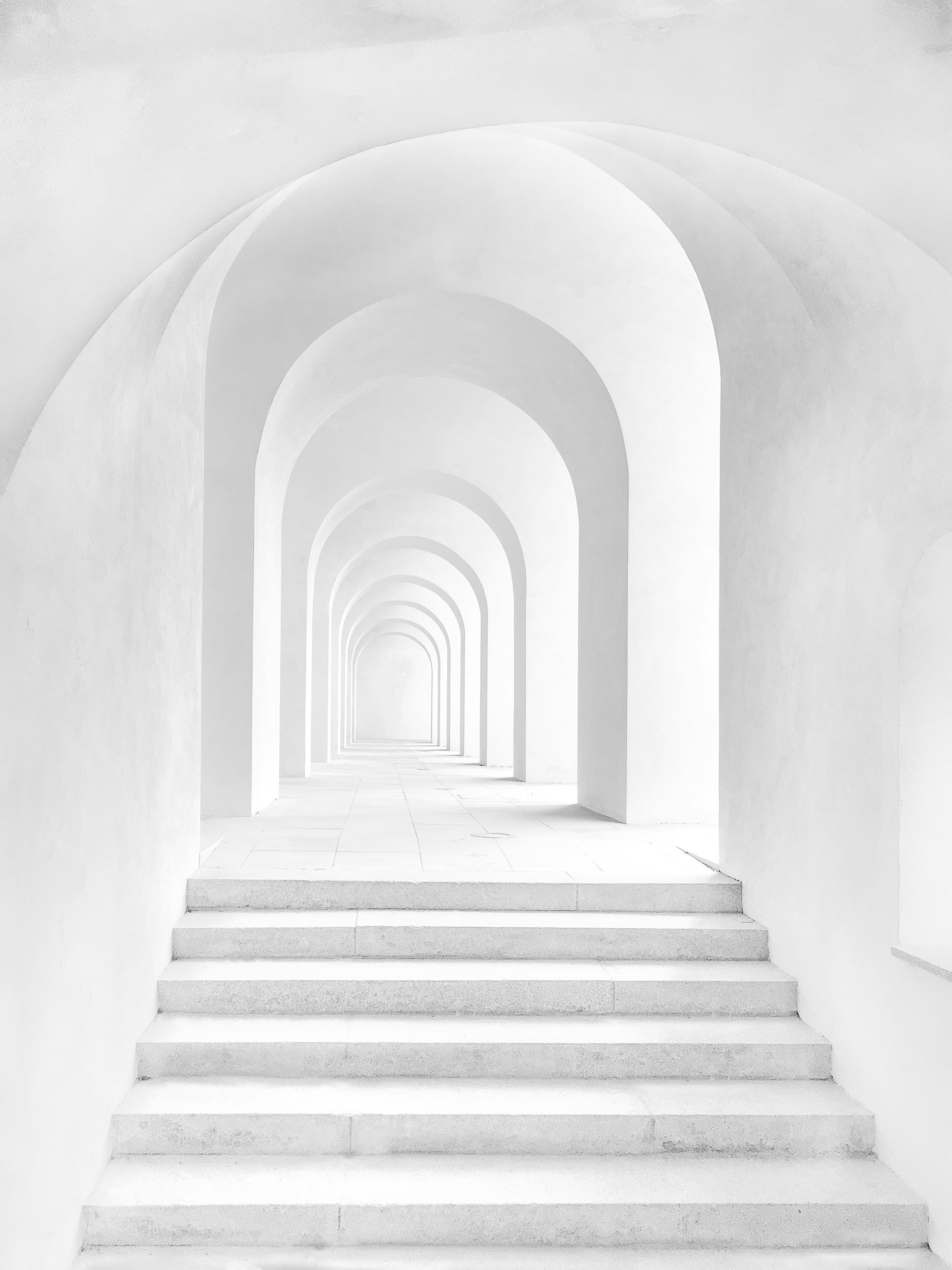 A receding sequence of white arches and steps