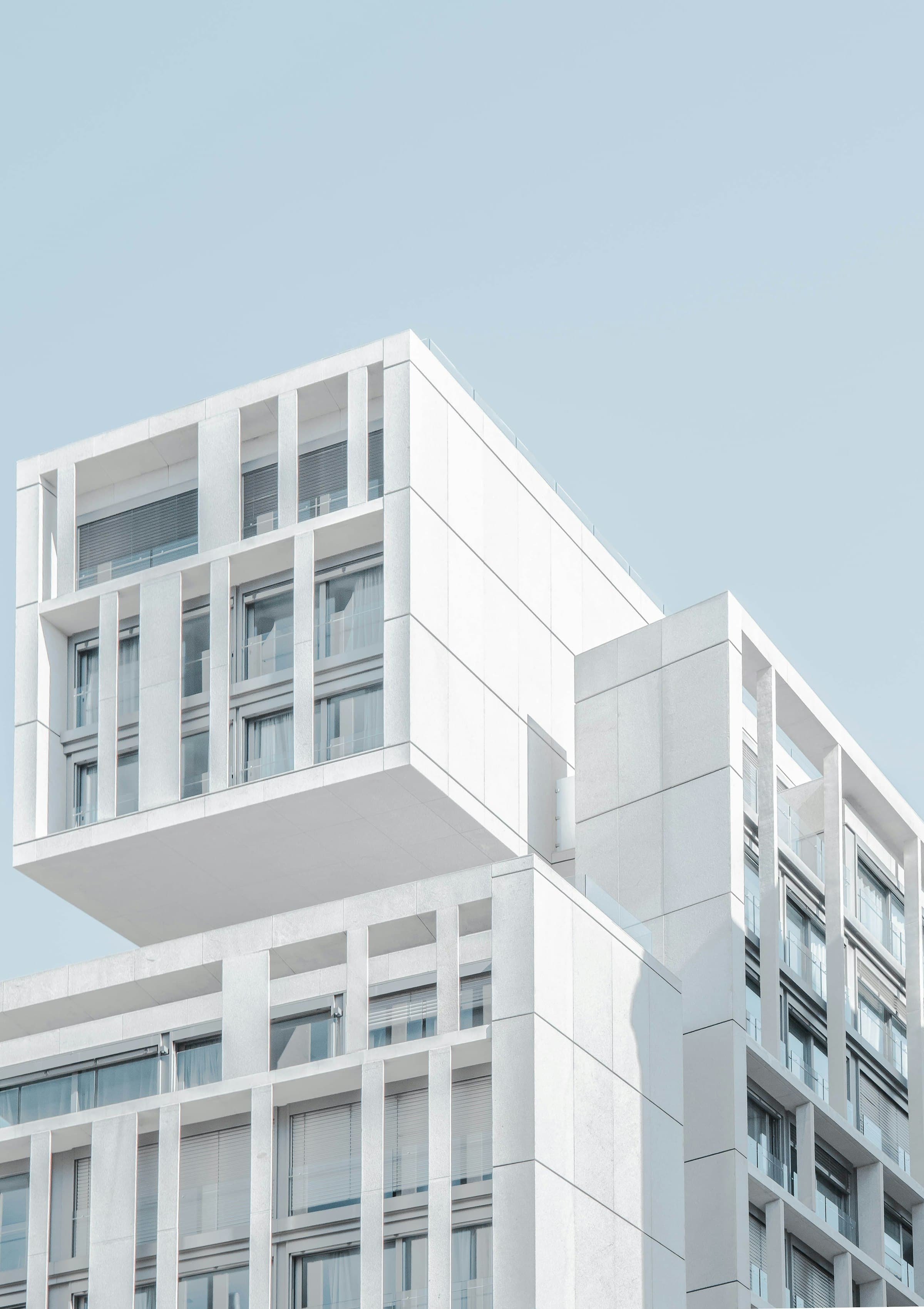 A white modular building facade with stacked volumes