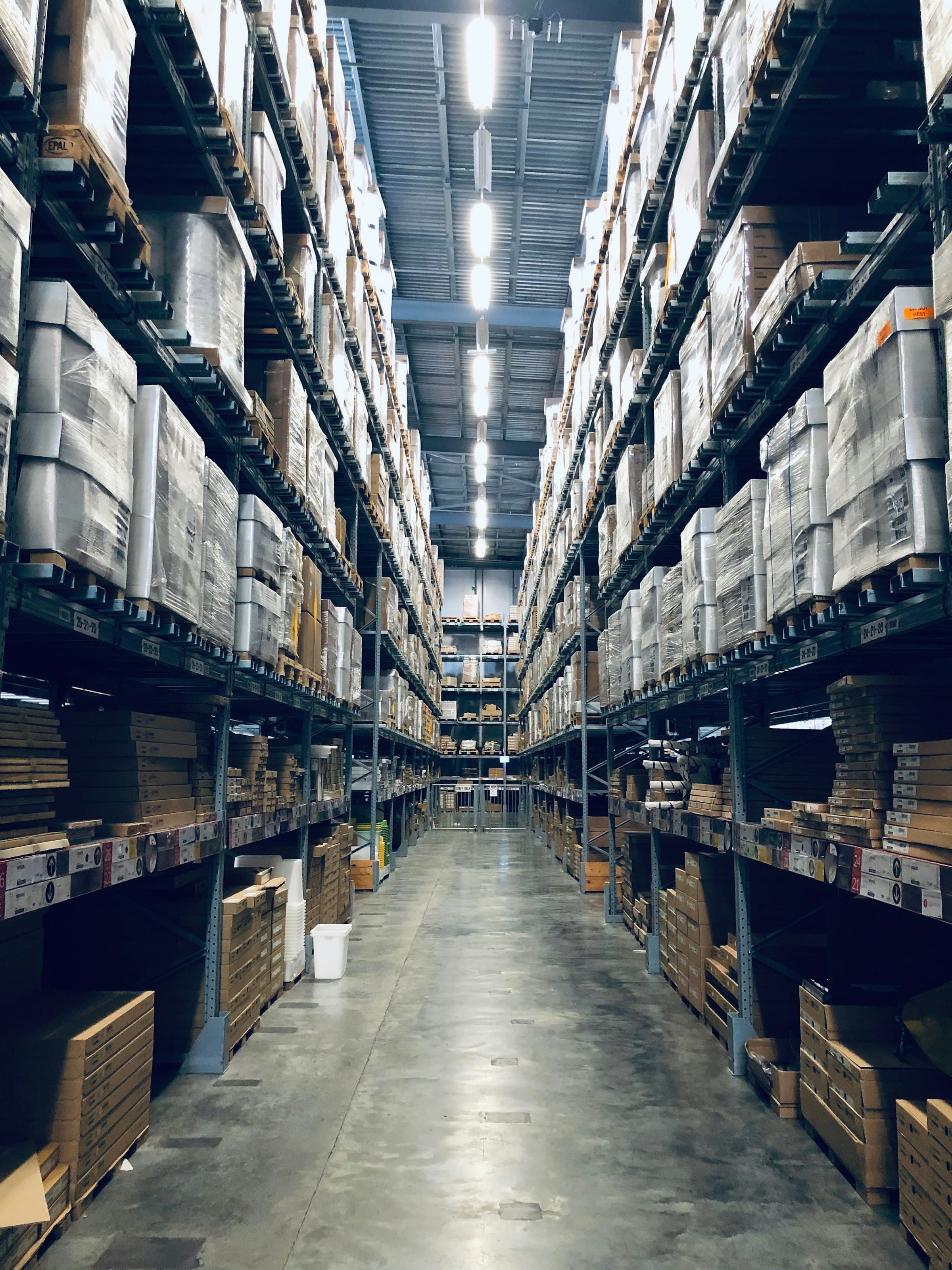A tall warehouse aisle lined with high-bay storage racks